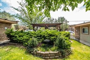 Farmington apartment for rent - a backyard with a gazebo and a stone retaining wall