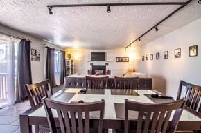 Farmington apartment for rent - a dining room table with chairs and a living room with a fireplace