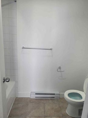 Chateauguay apartment for rent - a white bathroom with a toilet and a bath tub