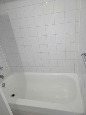 Chateauguay apartment for rent - a white tub in a bathroom with white tiled walls