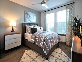 St. Petersburg apartment for rent - A bedroom with a bed, nightstand, and a ceiling fan.