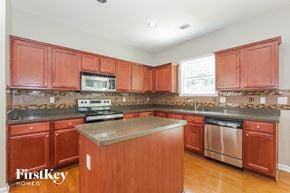 Lawrenceville house for rent - a kitchen with wooden cabinets and stainless steel appliances and granite counter tops