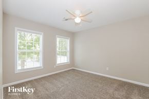 Lawrenceville house for rent - a bedroom with a ceiling fan and two windows