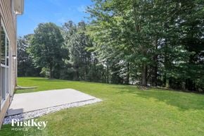 Lawrenceville house for rent - a backyard with grass and trees and a concrete driveway