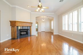 Moore house for rent - A spacious room with a fireplace and wooden floors.