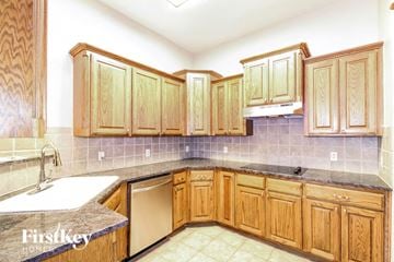 Moore house for rent - A kitchen with wooden cabinets and a dishwasher.