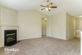 Raleigh house for rent - a living room with a fireplace and a ceiling fan