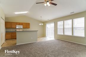 Raleigh house for rent - an empty living room with a kitchen and a ceiling fan