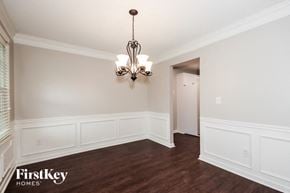 Hiram house for rent - a dining room with white walls and wood flooring and a chandelier