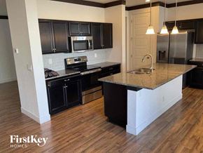Brighton house for rent - an updated kitchen with black cabinets and a granite counter top