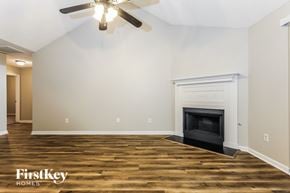 Newnan house for rent - A room with a fireplace and a ceiling fan.