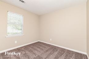 Mcdonough house for rent - the bedroom of a small house with carpet and a window