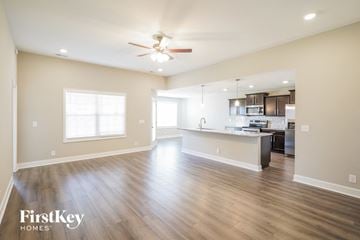 Clarksville house for rent - A spacious kitchen and living room with wood flooring and a ceiling fan.