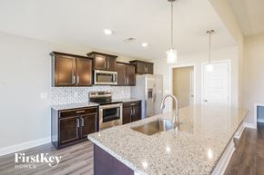 Clarksville house for rent - A kitchen with granite countertops and wooden cabinets.