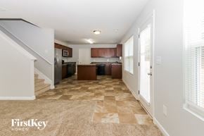 Covington house for rent - A spacious kitchen with a checkered floor and a staircase on the left.