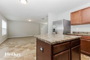 Covington house for rent - A kitchen with a granite countertop and wooden cabinets.