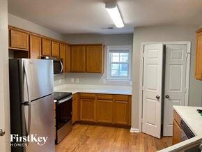 Charlotte house for rent - an empty kitchen with wooden cabinets and stainless steel appliances