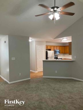 Charlotte house for rent - an empty living room and kitchen with a ceiling fan