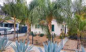 San Bernardino apartment for rent - a house with palm trees and a black fence