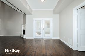 Montgomery house for rent - A spacious room with wooden floors and a white door.