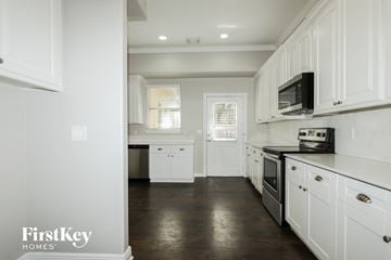 Montgomery house for rent - A kitchen with white cabinets and a black microwave.