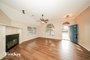 Oklahoma City house for rent - A spacious room with a fireplace and a ceiling fan.