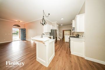 Oklahoma City house for rent - A kitchen with wooden floors and white cabinets.