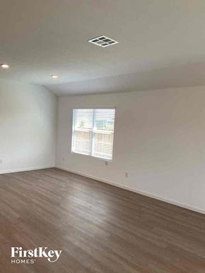 Bulverde house for rent - an empty living room with wood floors and a window