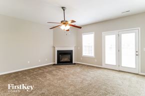 Winston-Salem house for rent - A spacious room with a fireplace and a ceiling fan.