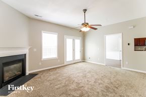 Winston-Salem house for rent - A spacious room with a fireplace and a ceiling fan.