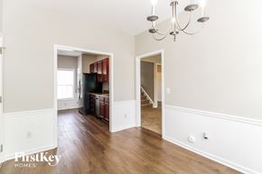 Winston-Salem house for rent - A room with a chandelier and wood floors.