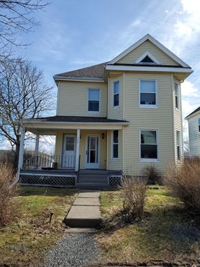 Stellarton apartment for rent - A yellow house with a porch and a small front yard.
