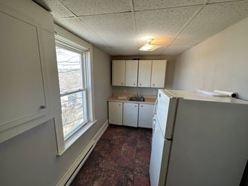 Stellarton apartment for rent - A kitchen with a refrigerator, cabinets, and a window.