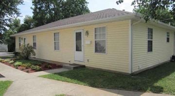 Springfield house for rent - A yellow house with a brown roof and a grey door.