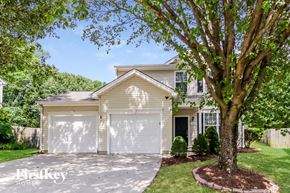 Winston-Salem house for rent - a white house with a white garage door and a tree