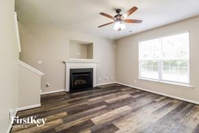 Winston-Salem house for rent - a living room with a fireplace and a ceiling fan