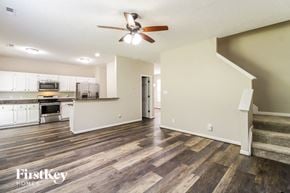 Winston-Salem house for rent - an empty living room and kitchen with a ceiling fan