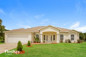 Lehigh Acres house for rent - a beige house with a lawn in front of it