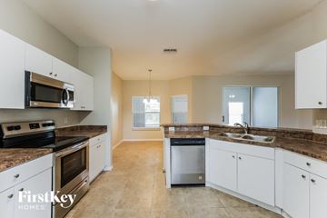 Lehigh Acres house for rent - a large kitchen with white cabinets and granite counter tops