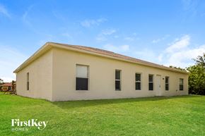 Lehigh Acres house for rent - an old white building with a grassy yard in front of it
