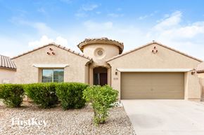 Laveen house for rent - A beige house with a brown roof and a garage door.