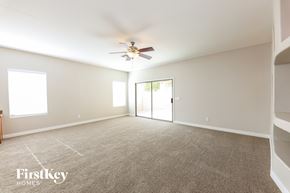 Laveen house for rent - A spacious room with a ceiling fan and a sliding glass door leading to a balcony.