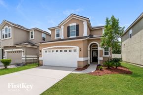 Jacksonville house for rent - a beige house with a white garage door