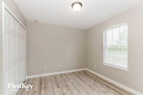 Jacksonville house for rent - an empty bedroom with wood flooring and a white door