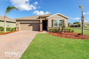 Palm Bay house for rent - A house with a driveway and a palm tree in front.