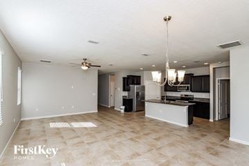 Palm Bay house for rent - A spacious kitchen and living room with a tile floor and a chandelier.