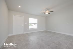 Lehigh Acres house for rent - an empty living room with a ceiling fan and a window
