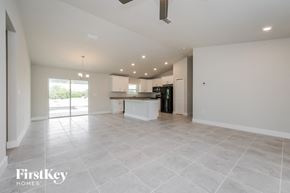 Lehigh Acres house for rent - an empty living room and kitchen with a sink and refrigerator