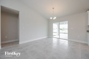 Lehigh Acres house for rent - an empty living room with a sliding glass door to the patio