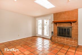 Tucson house for rent - the living room has a brick fireplace and a door to the patio